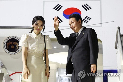 윤석열 대통령과 김건희 여사가 한ㆍ아세안 정상회의 등의 일정을 마친 뒤 주요 20개국(G20) 정상회의가 열리는 인도네시아 발리로 출국하기 위해 지난 13일(현지시간) 캄보디아 프놈펜국제공항에 도착, 공군 1호기에서 인사하고 있다. [프놈펜=연합뉴스]